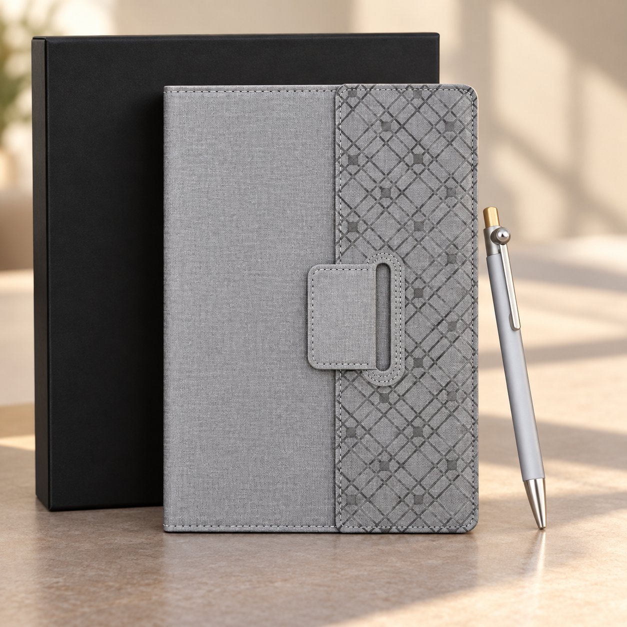 Grey notebook set of 2: A5 notebook with patterned magnetic flap and silver fidget-ball pen beside a black gift box