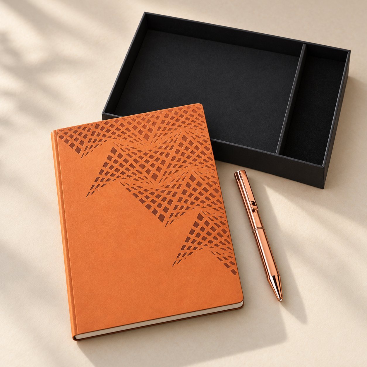 Brown A5 notebook with geometric embossed cover and rose-gold luster pen beside a black gift box