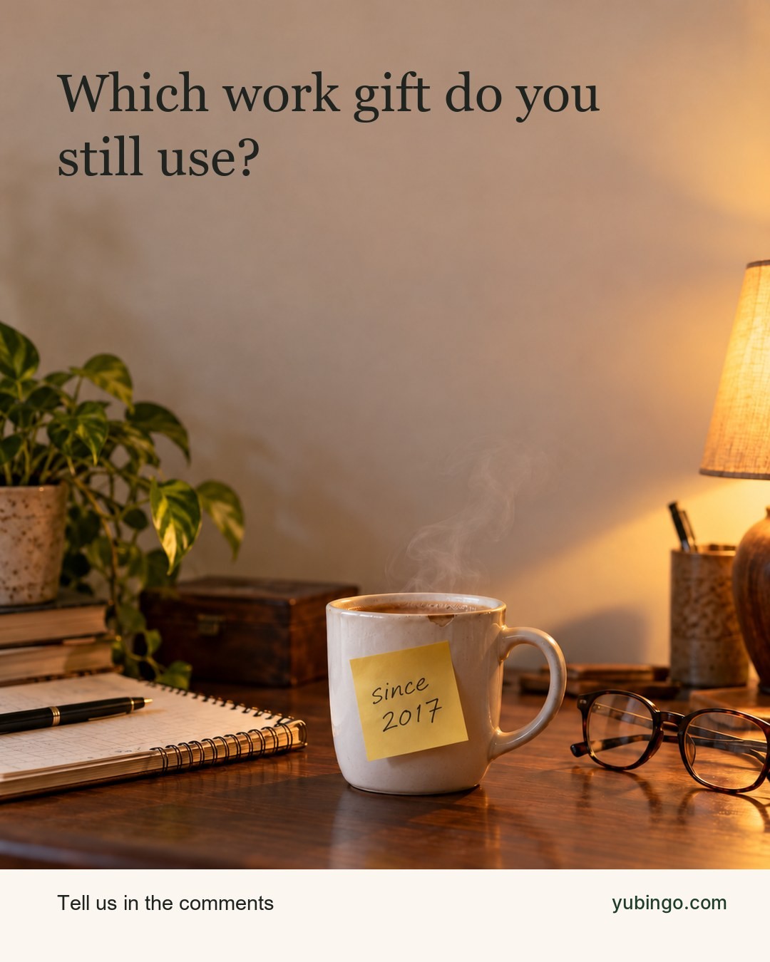 A worn white mug with a small chip on the rim, steaming on a home desk under lamp light, with a sticky note that says since 2017. Text: Which work gift do you still use?