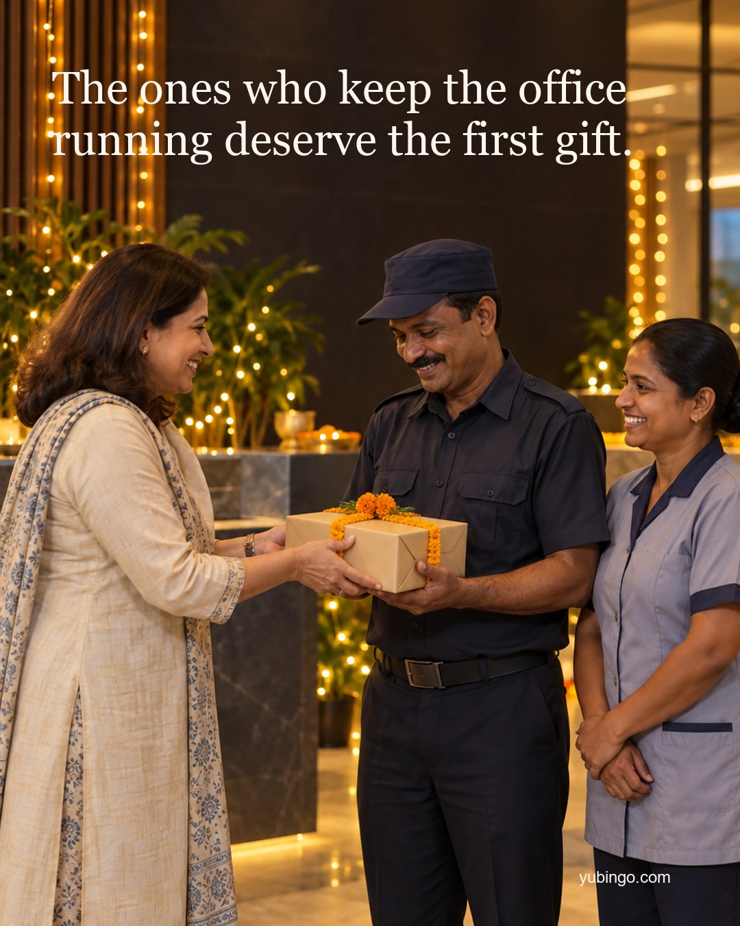 In a festive office lobby a woman manager hands a gift box with a marigold ribbon to a smiling security guard while a housekeeping colleague smiles beside him. Text: The ones who keep the office running deserve the first gift.